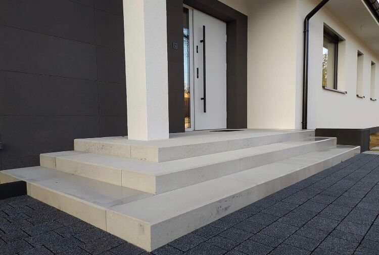 Breite Eingangstreppe mit hellen Stufen und dunkler Fassade
