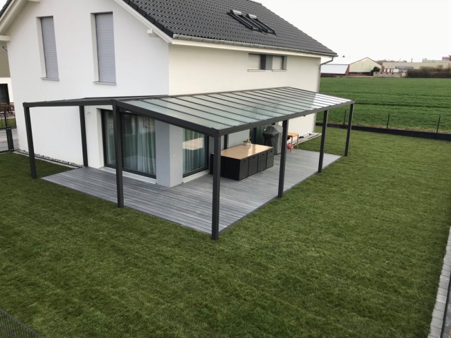 Überdachter Sitzplatz an einem Haus mit Rasenfläche